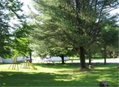 a park with a playground with trees and a slide at Four Seasons Motel in Catskill