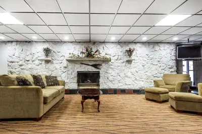 a lobby with couches and a stone wall at Quality Inn & Suites Binghamton Vestal in Binghamton