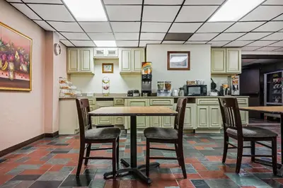 a restaurant with a table and chairs in a kitchen at Quality Inn & Suites Binghamton Vestal in Binghamton