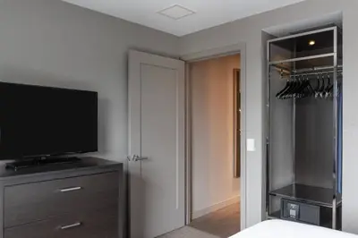 a bedroom with a flat screen tv and a closet at Residence Inn by Marriott Weehawken in Weehawken