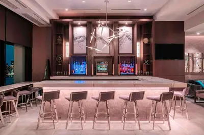 a bar in a room with stools and a table at Residence Inn by Marriott Weehawken in Weehawken