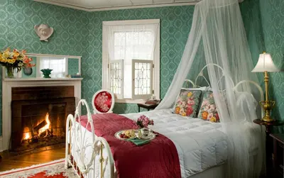 a bedroom with a bed and a fireplace at Hampton Terrace Inn in Lenox