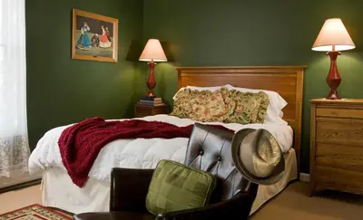 a bedroom with a bed with a hat on it at Hampton Terrace Inn in Lenox
