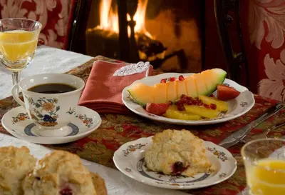 a table with two plates of fruit and a cup of coffee at Hampton Terrace Inn in Lenox