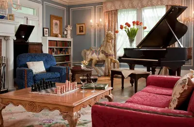 a living room with a piano and a table with chess at Hampton Terrace Inn in Lenox