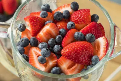 a glass bowl filled with strawberries and blueberries and strawberries and blueberries at Grand Colonial Bed and Breakfast in Herkimer