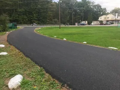 a winding road in a park with a green field at Catskill Motor Court in Catskill