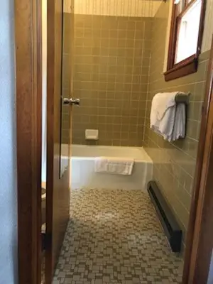 a bathroom with a shower with a tub and a toilet at Catskill Motor Court in Catskill