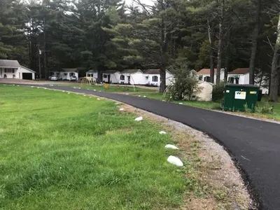 an empty road with grass and houses on the side at Catskill Motor Court in Catskill