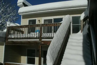 a house with a deck covered in snow at Townhouse W Private Deck & Mt View in Windham