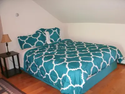 a bedroom with a bed with a blue and white comforter at Townhouse W Private Deck & Mt View in Windham