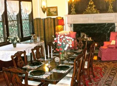 a dining room with a table and chairs and a fireplace at Whistler's Inn in Lenox