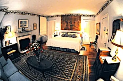 a large bedroom with a bed and a fireplace at Whistler's Inn in Lenox