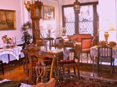 a living room with a table and chairs and a clock at Whistler's Inn in Lenox
