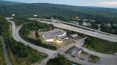 an aerial view of a parking lot next to a highway at Holiday Inn Scranton East - Dunmore by IHG in Dunmore