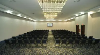 an empty room with chairs and a chandelier at Holiday Inn Scranton East - Dunmore by IHG in Dunmore