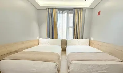 two beds in a small room with a window at Madison LES Hotel in New York