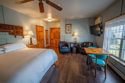 a bedroom with a bed and a table and chairs at Albergo Allegria Hotel & Breakfast Restaurant in Windham
