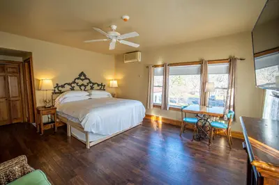 a bedroom with a bed and a table and chairs at Albergo Allegria Hotel & Breakfast Restaurant in Windham
