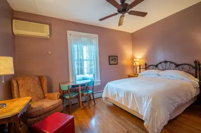 a bedroom with a bed and a table and a chair at Albergo Allegria Hotel & Breakfast Restaurant in Windham
