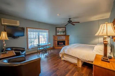 a bedroom with a bed and a desk and a television at Albergo Allegria Hotel & Breakfast Restaurant in Windham