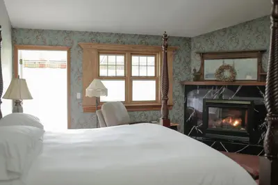 a bedroom with a bed and a fireplace at Albergo Allegria Hotel & Breakfast Restaurant in Windham