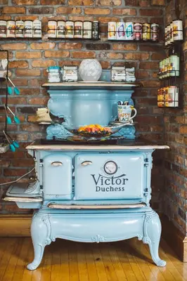 an old blue stove in a room with a brick wall at Albergo Allegria Hotel & Breakfast Restaurant in Windham
