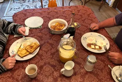 two people sitting at a table with breakfast food at Antique Rose Inn Windham in Windham