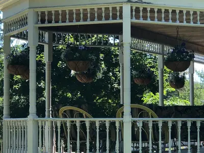 a porch with chairs and potted plants on it at Antique Rose Inn Windham in Windham