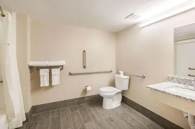 a bathroom with a toilet and a sink at Fairmount Inn & Suites - Stroudsburg, Poconos in Delaware Water Gap