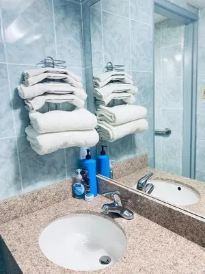a bathroom with a sink and a mirror and towels at Tides Inn at Stehli Beach in Locust Valley