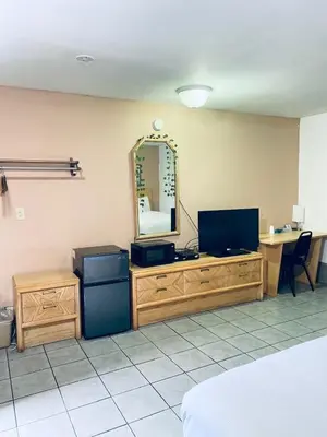 a room with a television and a desk with a mirror at Tides Inn at Stehli Beach in Locust Valley