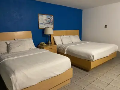two beds in a hotel room with blue walls at Tides Inn at Stehli Beach in Locust Valley