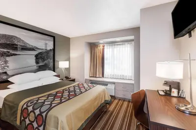 a hotel room with a bed and a desk at Super 8 by Wyndham Schenectady/Albany Area in Schenectady