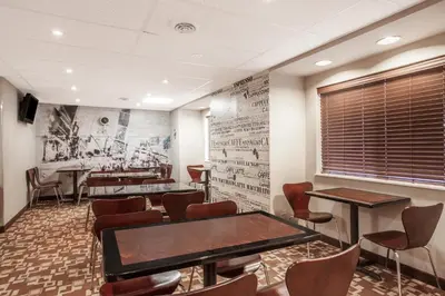 a waiting room with tables and chairs at Super 8 by Wyndham Schenectady/Albany Area in Schenectady
