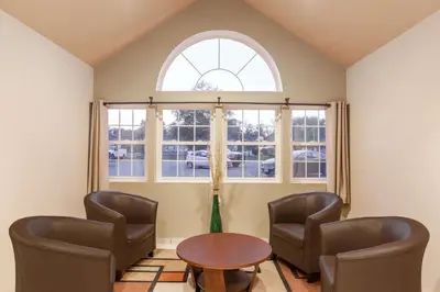 a room with two chairs and a table and a window at Super 8 by Wyndham Schenectady/Albany Area in Schenectady