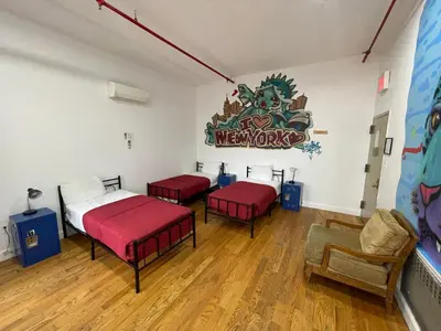 a room with two beds and a sign on the wall at NY Moore Hostel in Brooklyn
