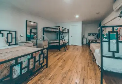 a bedroom with two bunk beds and wooden floors at NY Moore Hostel in Brooklyn