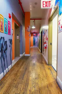 an empty hallway in an office with paintings on the walls at NY Moore Hostel in Brooklyn
