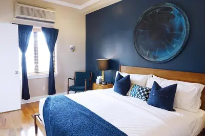 a bedroom with a large bed with blue walls at The Box House Hotel in Brooklyn