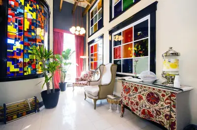 a room with a table and chairs and colorful windows at The Box House Hotel in Brooklyn