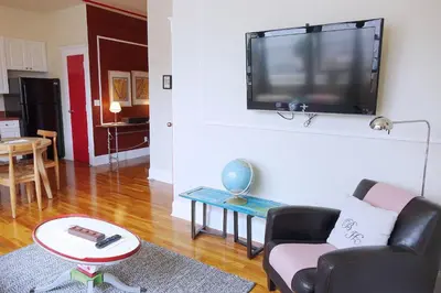 a living room with a tv hanging on a wall at The Box House Hotel in Brooklyn