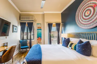 a bedroom with a large bed and a desk and chairs at The Box House Hotel in Brooklyn