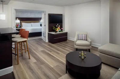 a hotel suite with a bed and a living room at Hilton Albany in Albany