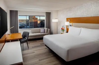a hotel room with a bed and a desk and a couch at Hilton Albany in Albany