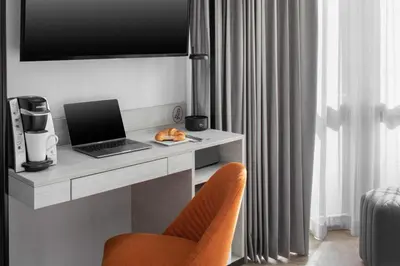a desk with a laptop and a chair in a room at voco Times Square South New York by IHG in New York