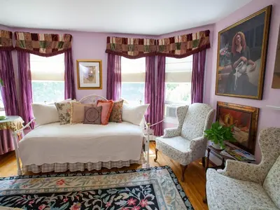 a bedroom with purple curtains and a bed and a chair at Fairlawn Inn in Hunter