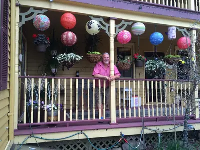 a woman standing on a porch with lanterns at Fairlawn Inn in Hunter
