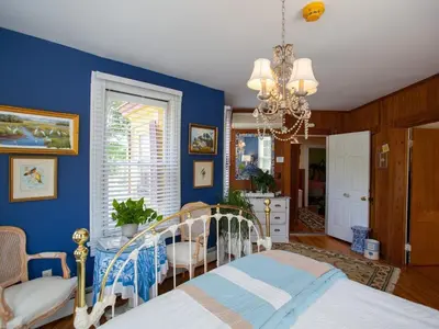 a blue bedroom with a bed and a chandelier at Fairlawn Inn in Hunter