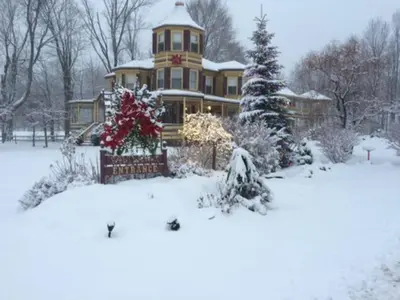a large house with a christmas tree in the snow at Fairlawn Inn in Hunter